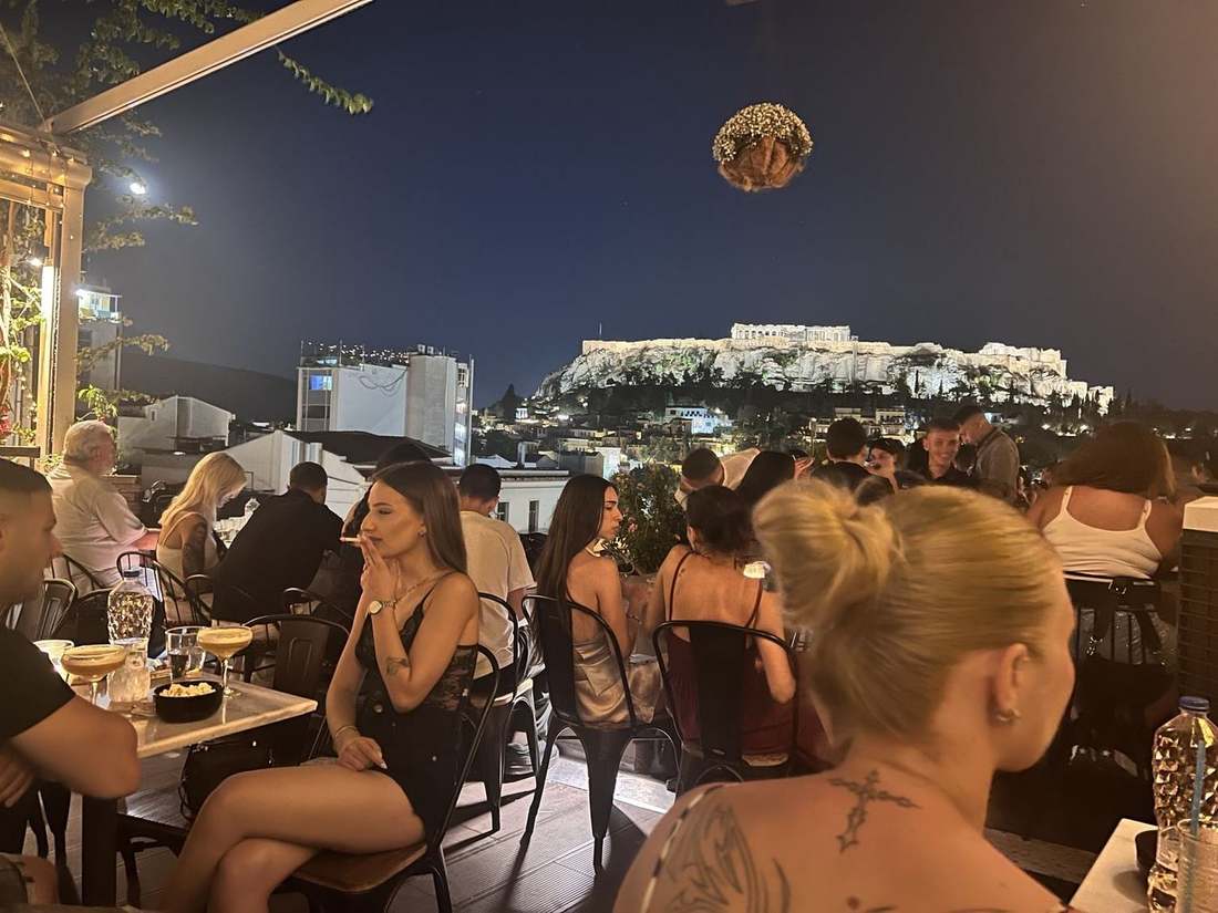 Athens rooftop lounge with illuminated Acropolis
